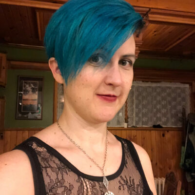 White Woman With Blue Short Hair Wearing A Black Lace Tank Top