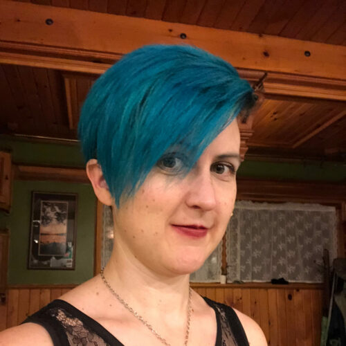 White Woman With Blue Short Hair Wearing A Black Lace Tank Top